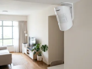 PIR passive infrared motion sensor mounted in the corner of a Singapore residential interior at ceiling height